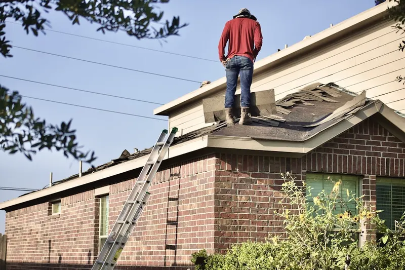 Professional roofer working on a residential roof in Hartland Village